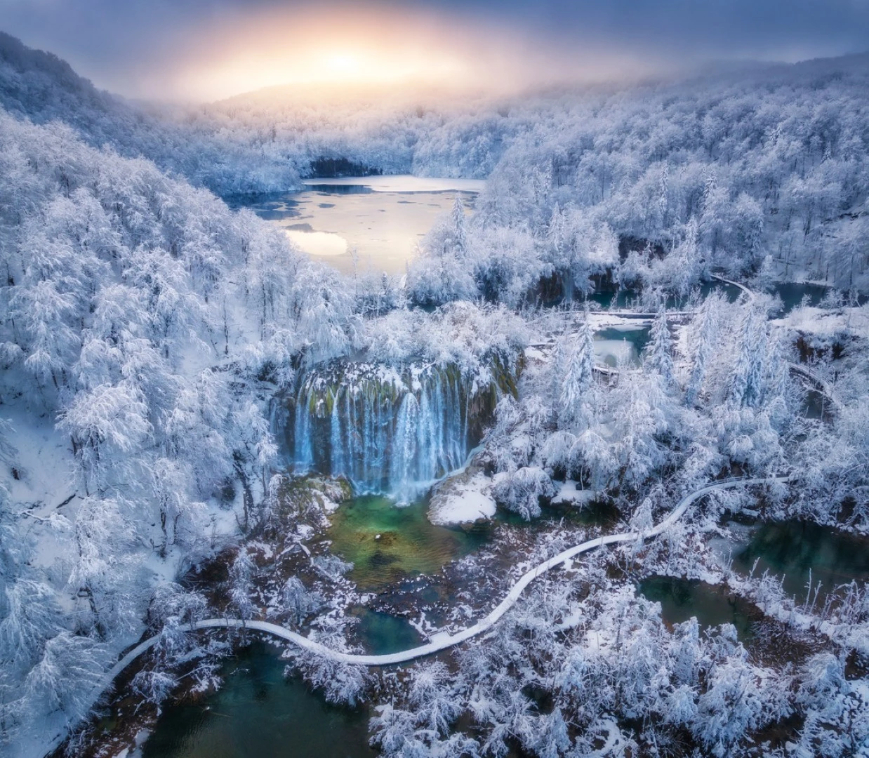 Plitviška jezera z zasneženimi drevesi v času zime.