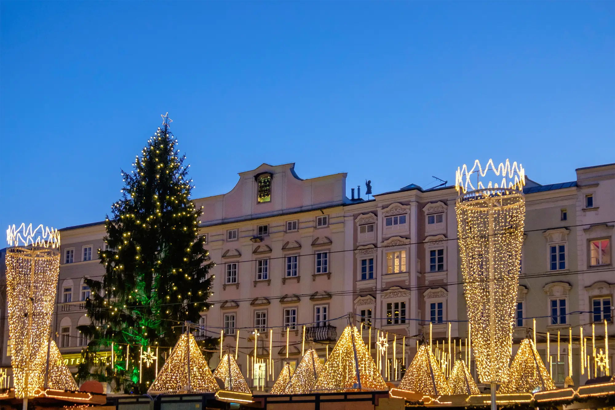 Adventni sejem na glavnem trgu Hauptplatz v Linzu s praznično okrašenim božičnim drevesom.