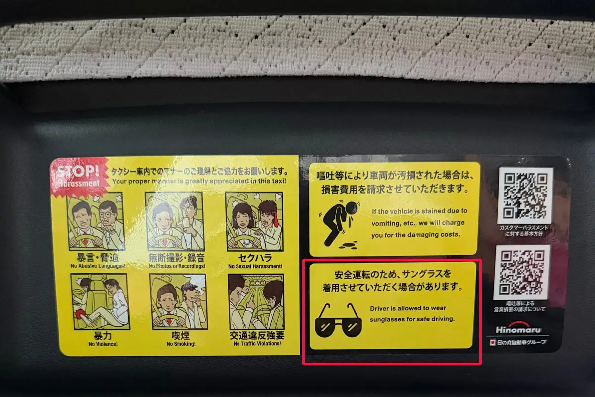 Obvestilo v japonskem taksiju pojasnjuje, da voznik lahko nosi sončna očala zaradi varne vožnje.