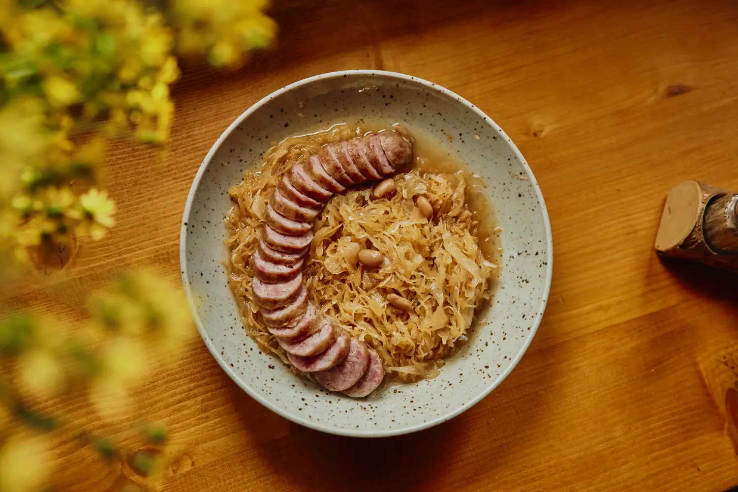 Traditional Slovenian dish of Carniolan sausage served with sauerkraut and beans – a hearty Alpine comfort food that reflects Slovenia’s rustic culinary heritage.