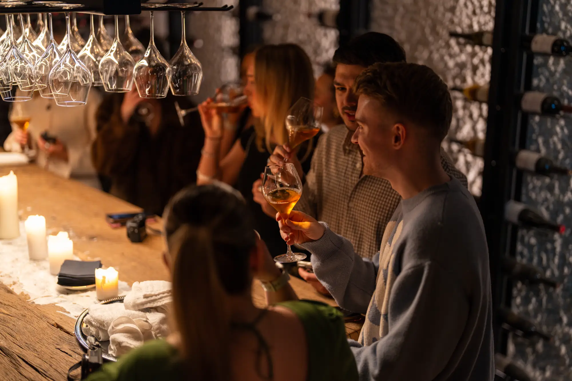 Na dogodku se skupina ljudi pogovarja in druži ob kozarcu vina