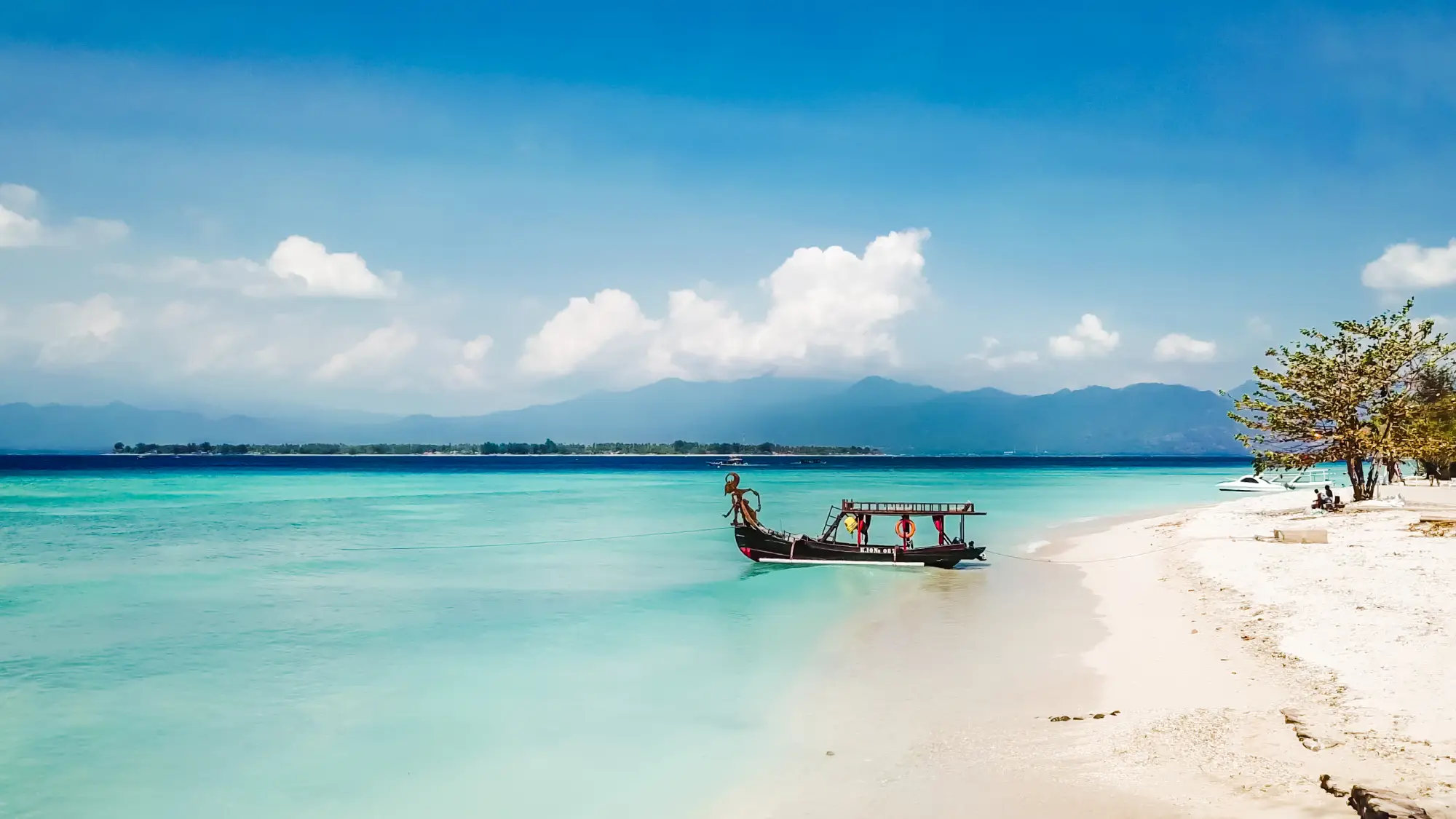 Gili Air obala s tradicionalnim čolnom v kristalno čistem morju