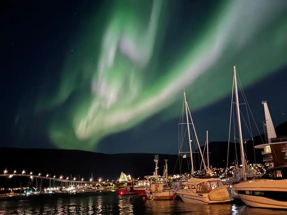 Severni sij nad marino v Tromsøju – aurora nad mestnimi lučmi