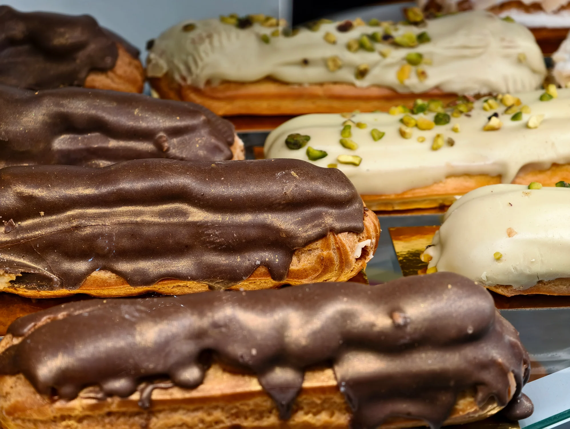 Čokoladni in pistacijev eclair v pekarni