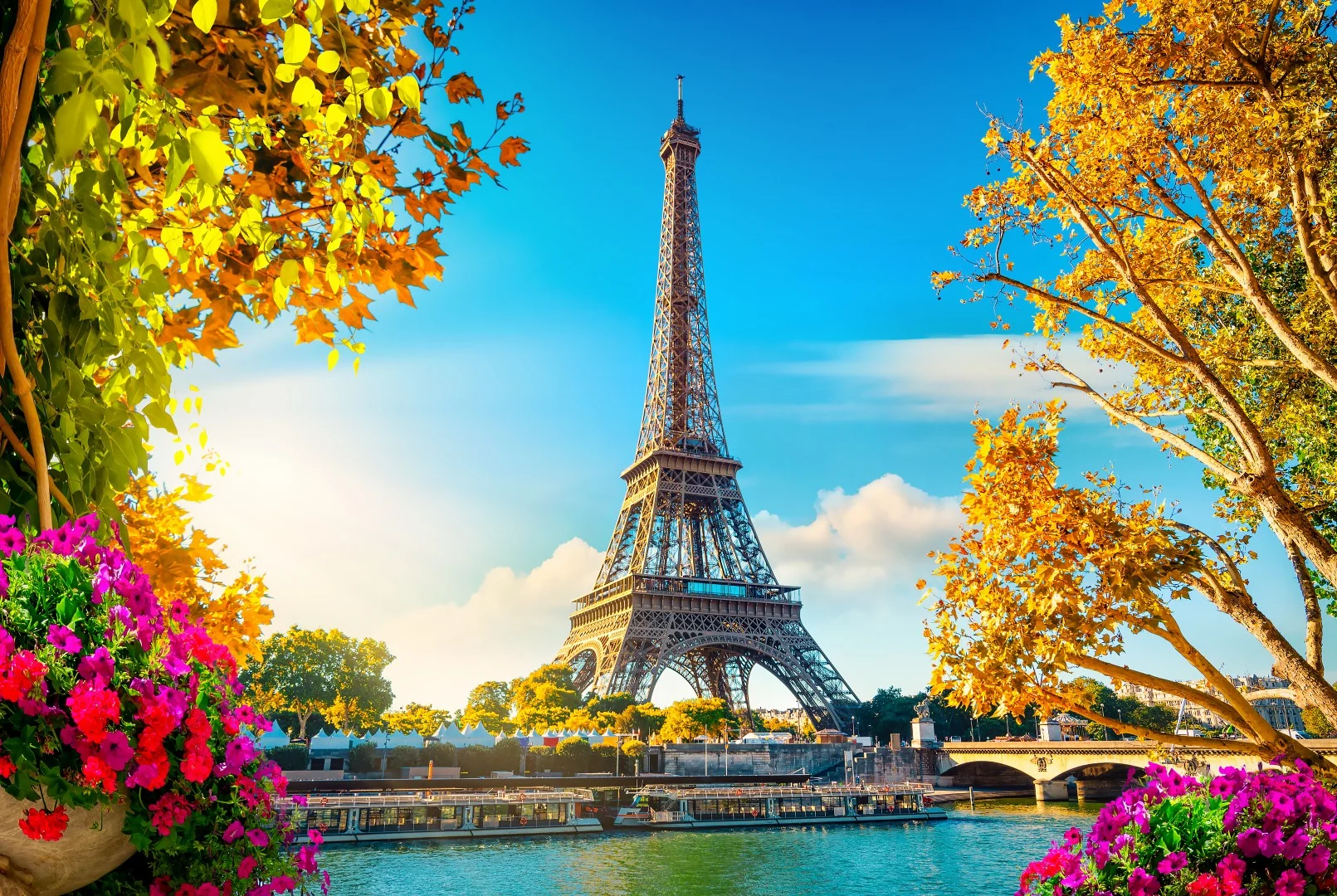 Pogled na Eiffel Tower, obdan z drevesi v jesenskih barvah.