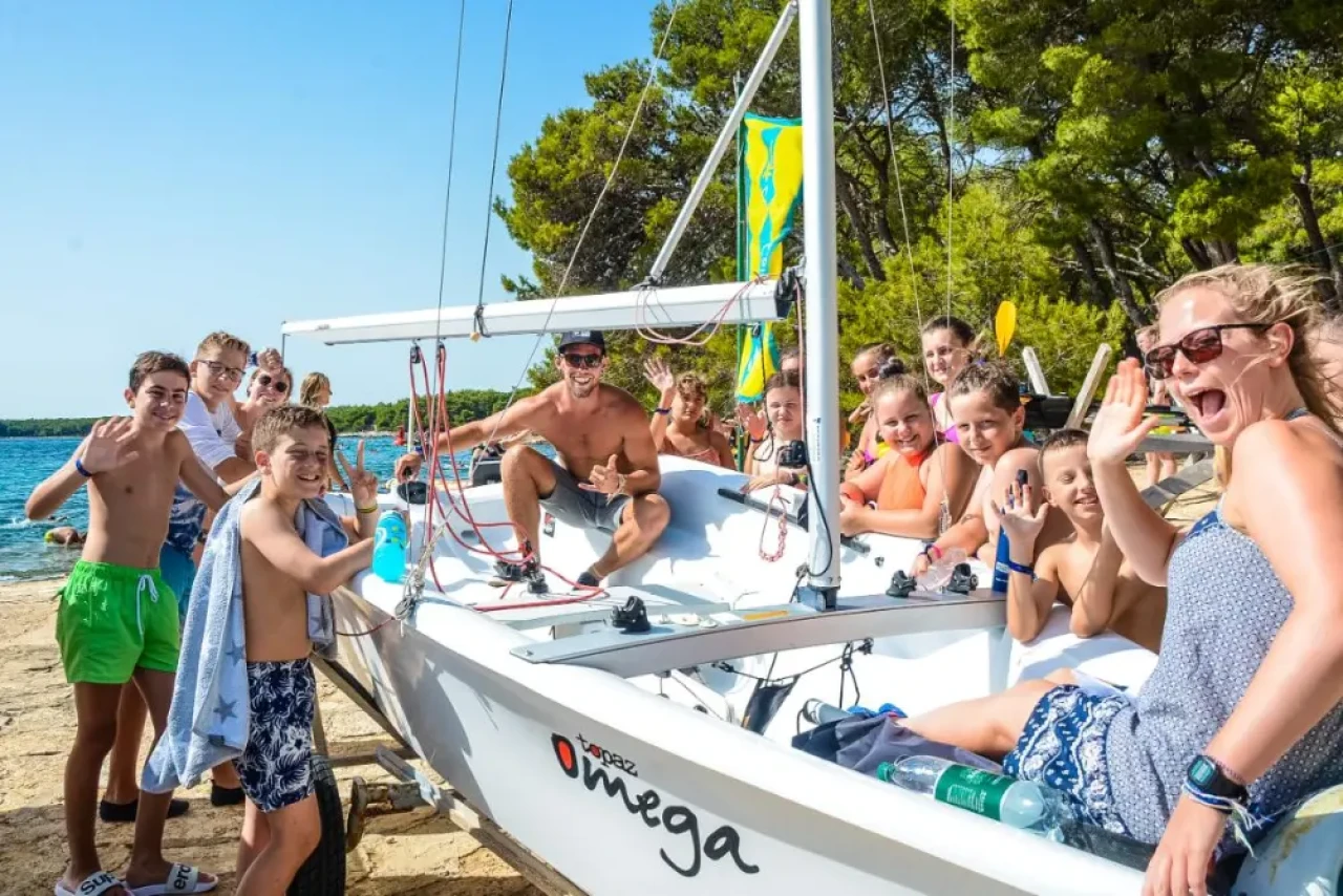 Skupina otrok in inštruktor na jadrnici v poletnem jadralnem taboru Camp California