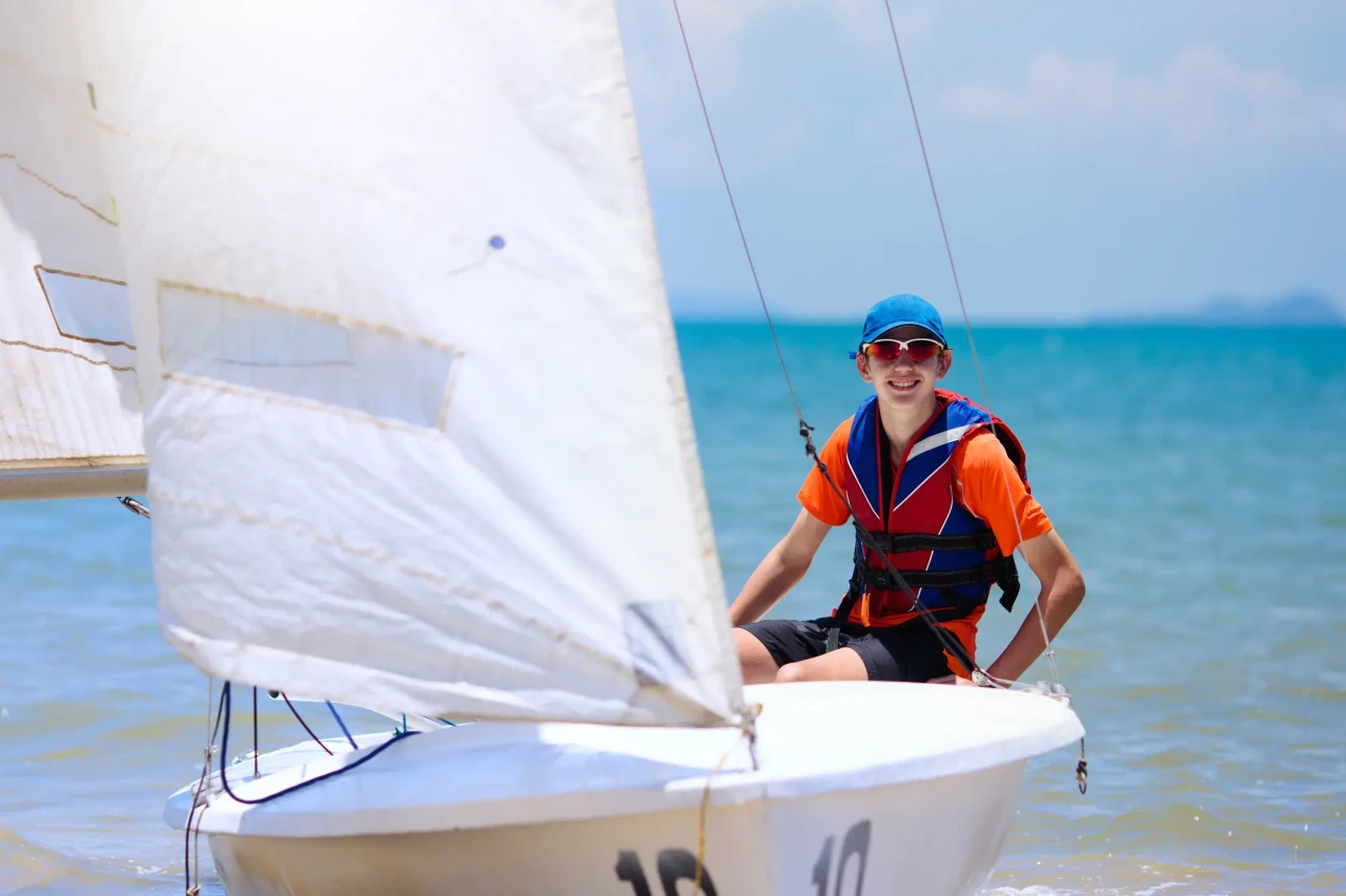 Najstnik jadra na manjši jadrnici v sklopu programa Teen Sailing v Camp California