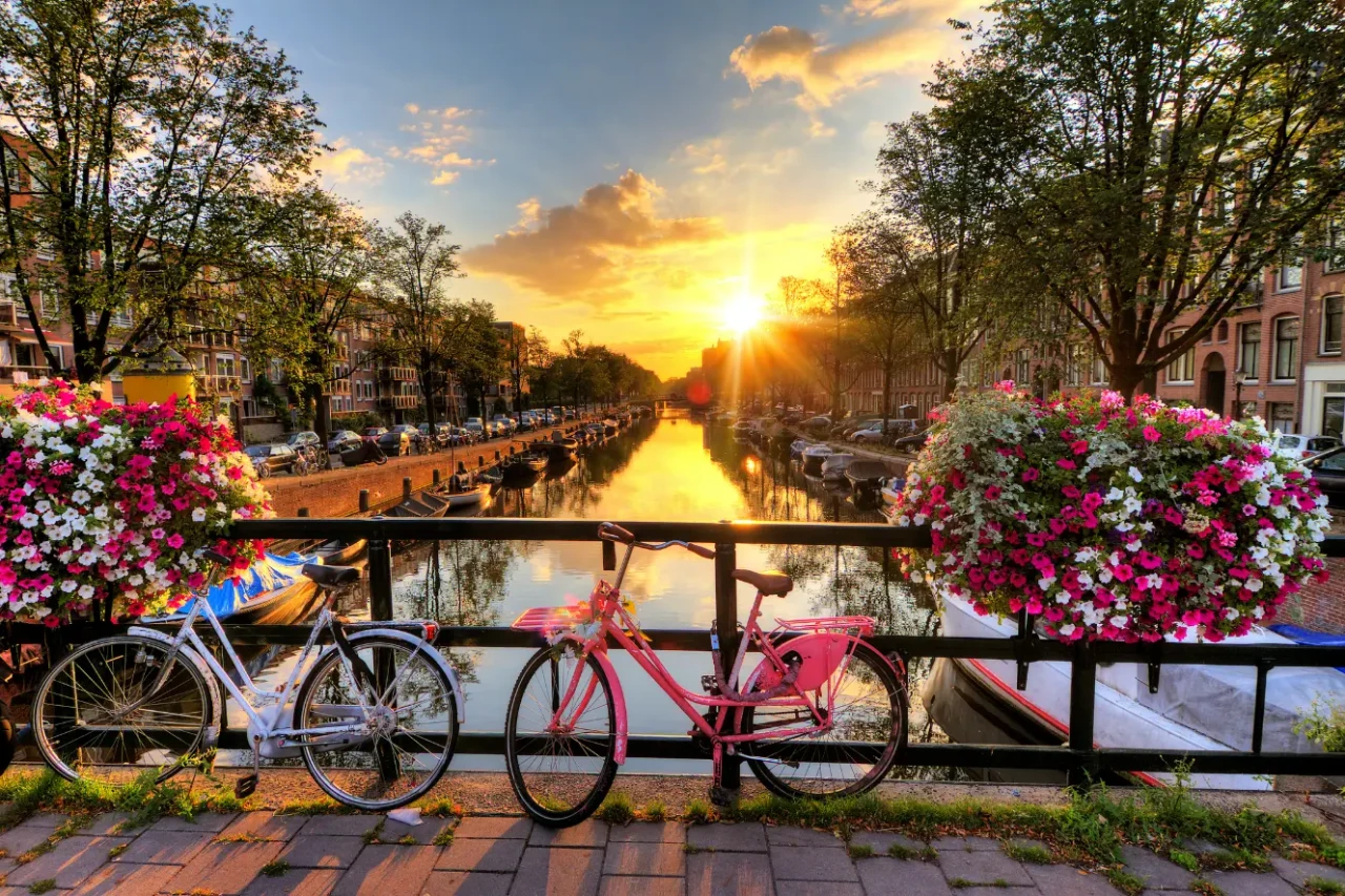 Pogled na kolesa in kanal v Amsterdamu ob sončnem zahodu