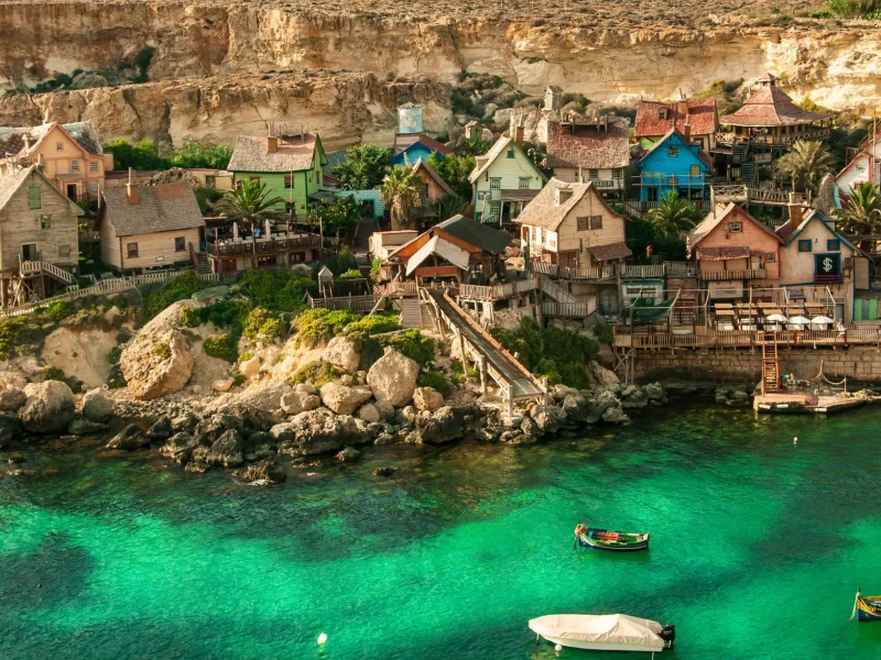Popeye Village na Malti ob turkiznem morju in skalnati obali.