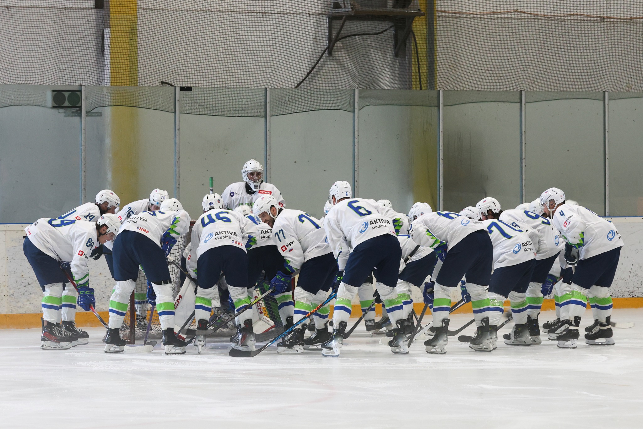 Slovenska hokejska reprezentanca zbrana pred golom med tekmo