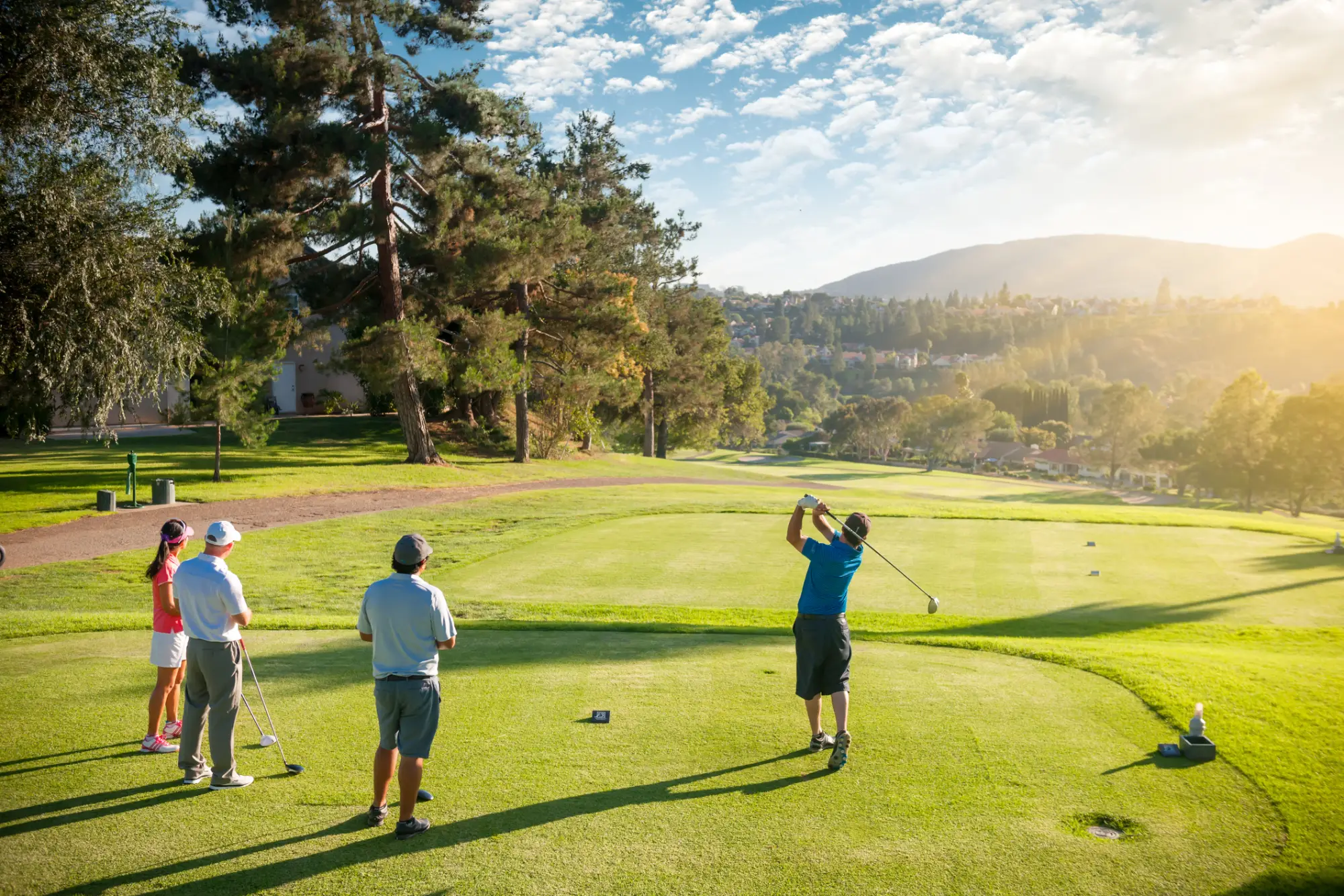 Skupina golfistov igra golf na igrišče v sončnem vremenu
