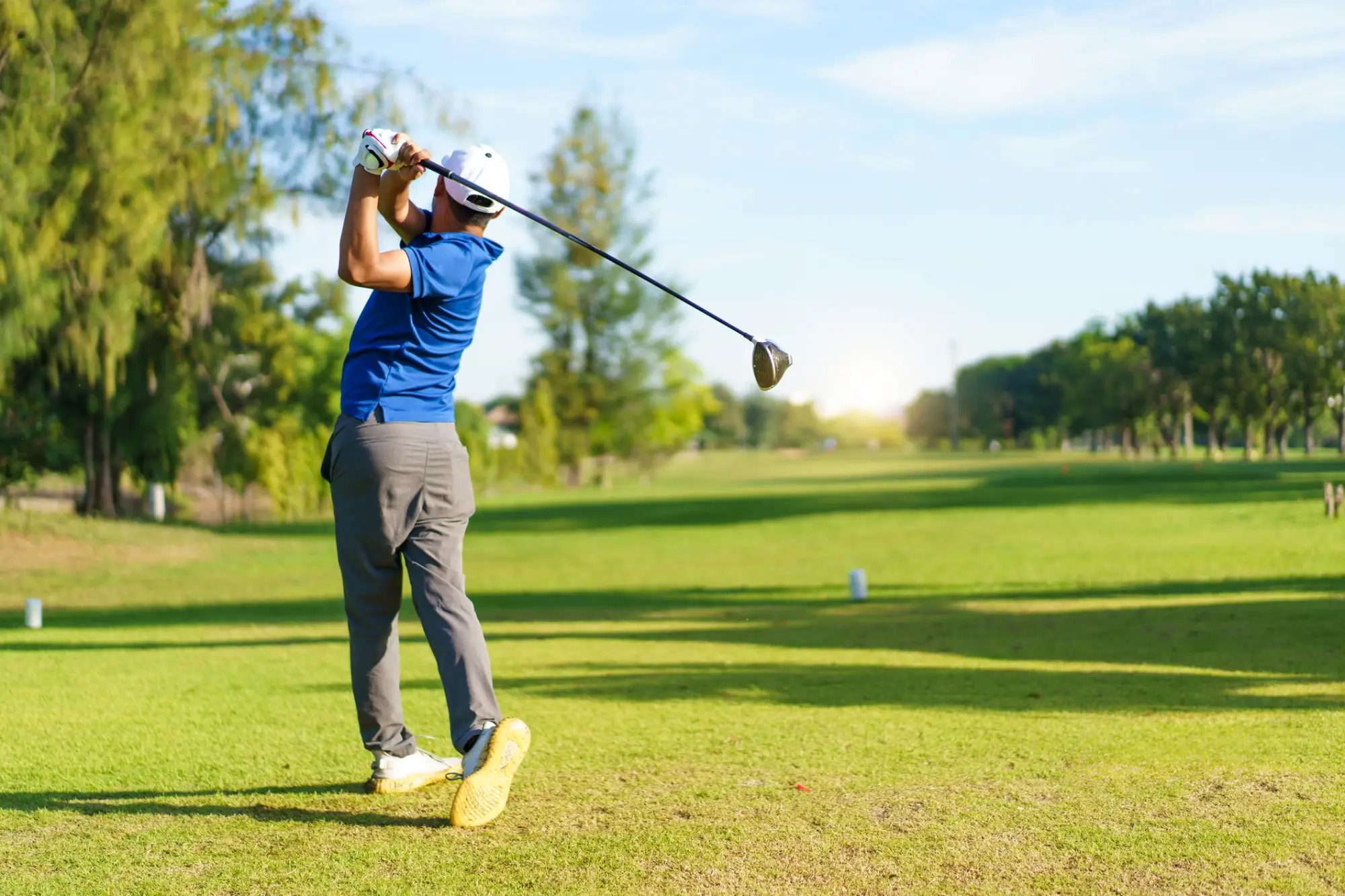Golfist na golf igrišču udarja žogico